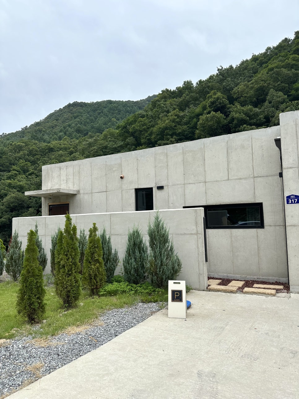 산자락에 들어선 노출 콘크리트 독채 외관